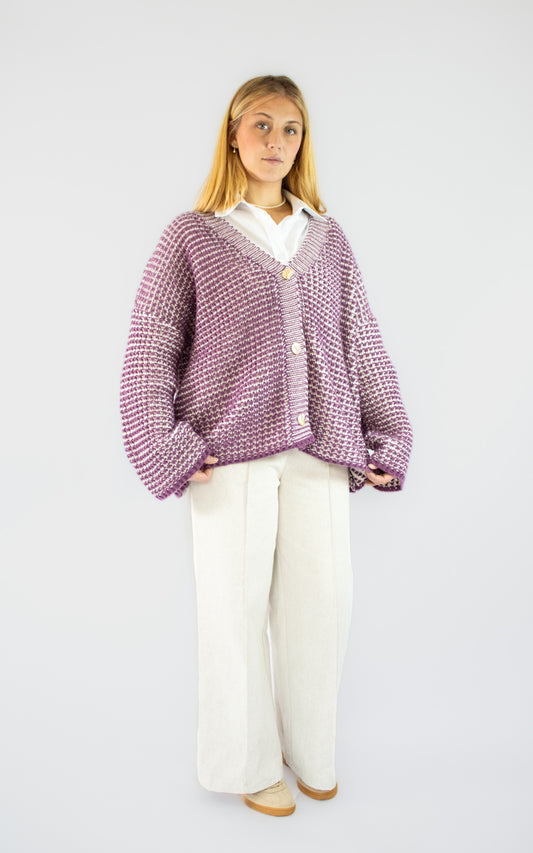 Cardigan en maille violet pour femme avec boutons dorés porté sur une chemise blanche et un pantalon fluide beige, tenue de prêt-à-porter élégante BySaphir.